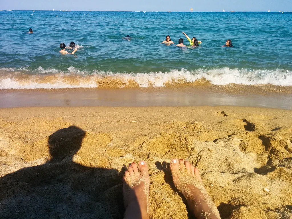 Relaxing on the Sand: Sunbathing and Swimming in Barcelona, Spain
